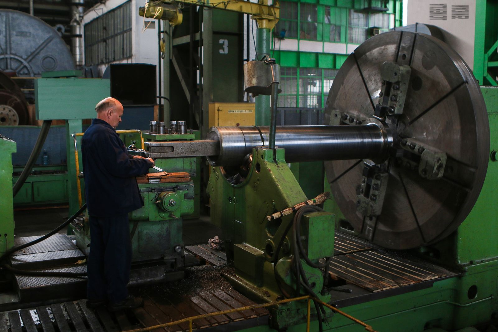Machiniste qualifié inspectant une pièce usinée à l'atelier Alchemical Machines